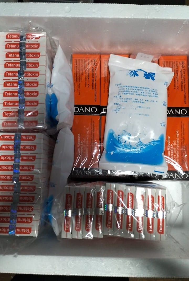 Packaged items including a box labeled 'Dano-TT' and Tetanus 1500ui with ice packets on a white surface.