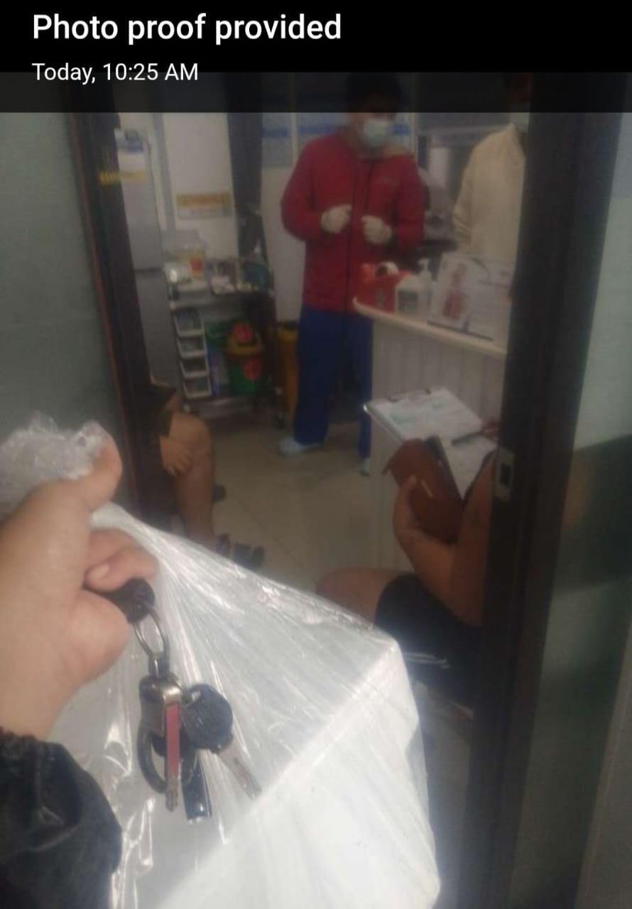 Rider holding wrapped styro package with a background of ABC clinic and doctors.