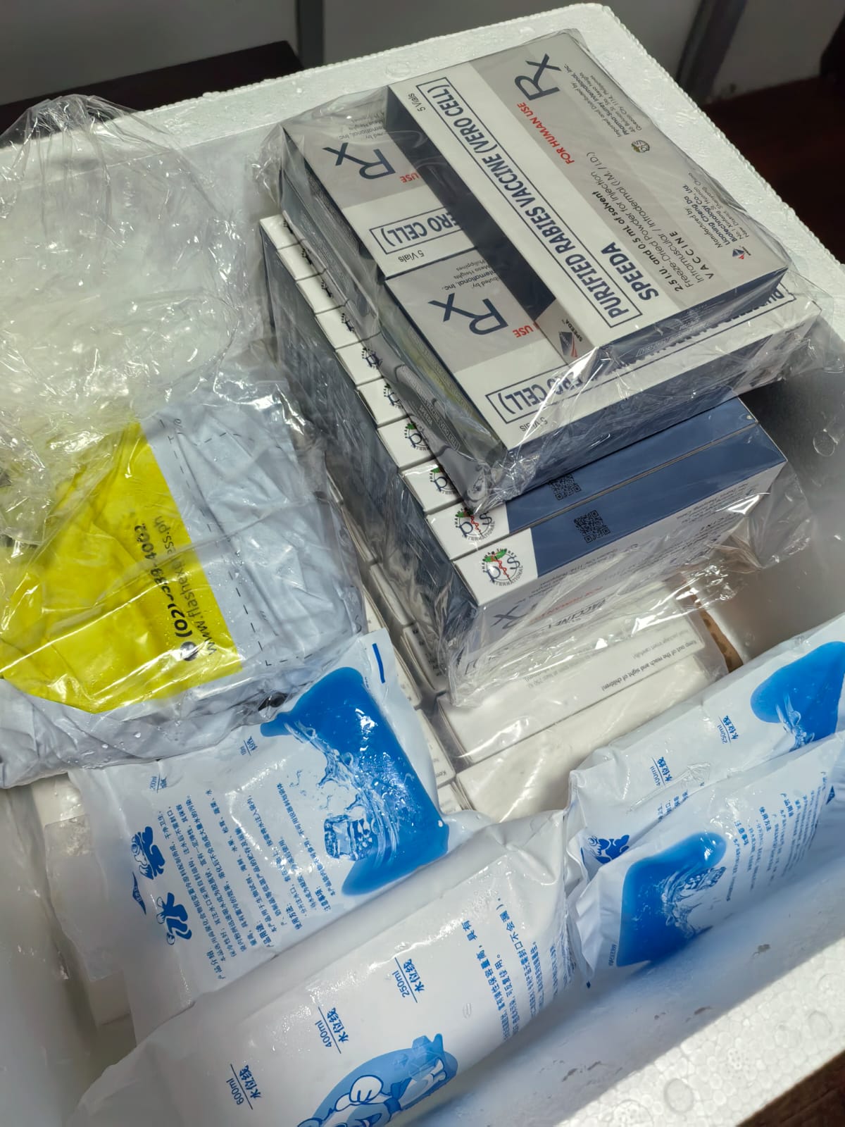 Medical supplies including boxes and rolls of gauze in a container.